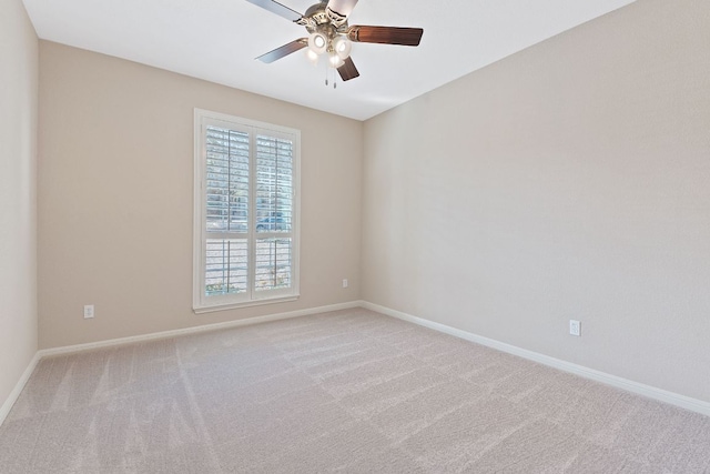 empty room with a ceiling fan, baseboards, and light carpet