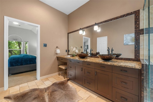 ensuite bathroom featuring connected bathroom, baseboards, and vanity