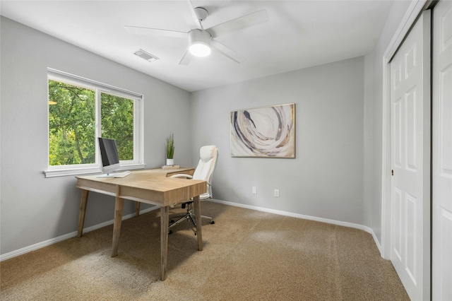 office space with visible vents, baseboards, carpet flooring, and a ceiling fan