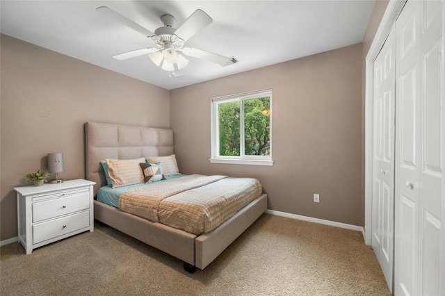 bedroom with visible vents, ceiling fan, baseboards, light carpet, and a closet