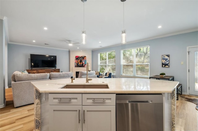 kitchen with a sink, crown molding, open floor plan, and stainless steel dishwasher