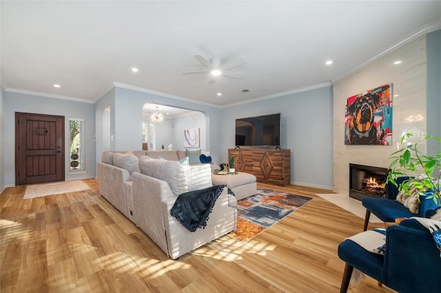 living room with recessed lighting, a large fireplace, a ceiling fan, and light wood finished floors