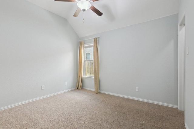 spare room with baseboards, light carpet, a ceiling fan, and vaulted ceiling