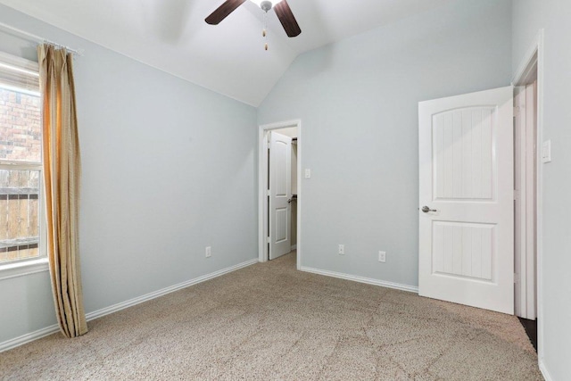 unfurnished bedroom featuring ceiling fan, baseboards, lofted ceiling, and carpet floors