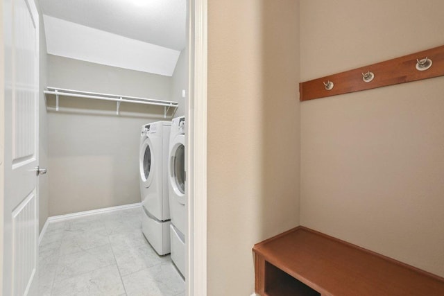 laundry room featuring washing machine and clothes dryer, laundry area, and baseboards