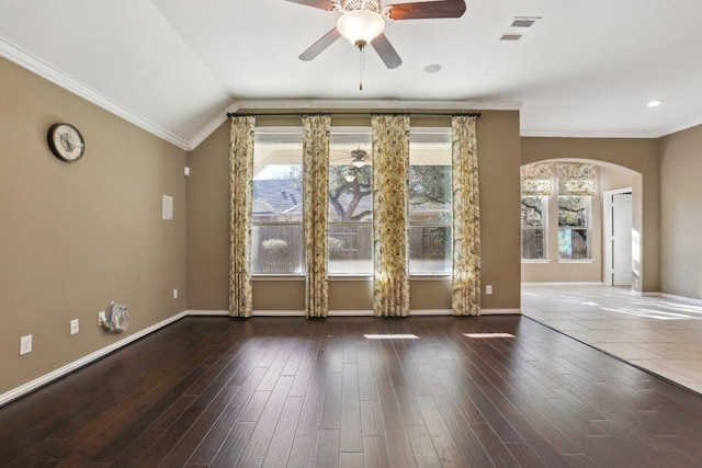 empty room with visible vents, wood finished floors, arched walkways, and ceiling fan