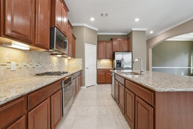 kitchen featuring light stone countertops, visible vents, arched walkways, a sink, and appliances with stainless steel finishes