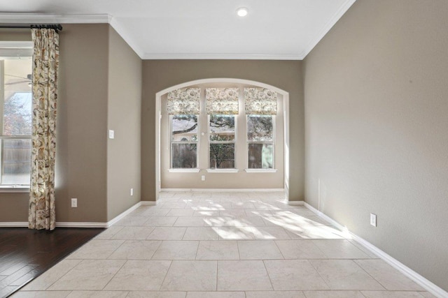 tiled empty room with baseboards and ornamental molding