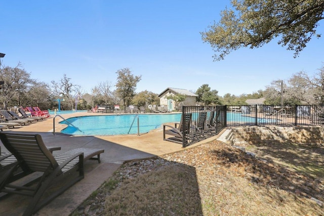 pool with a patio area and fence