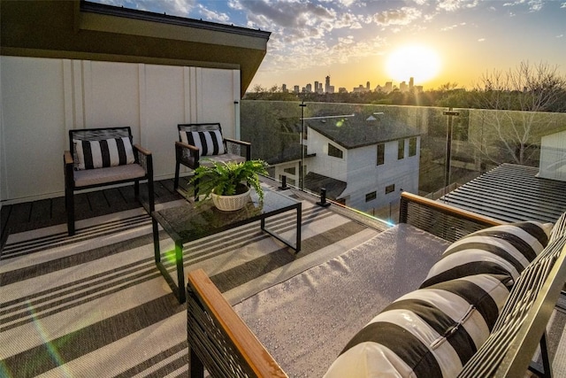 balcony at dusk featuring a city view