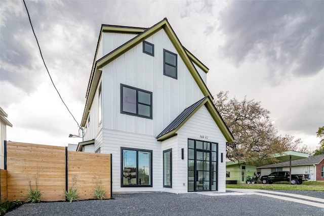 back of property featuring board and batten siding and fence