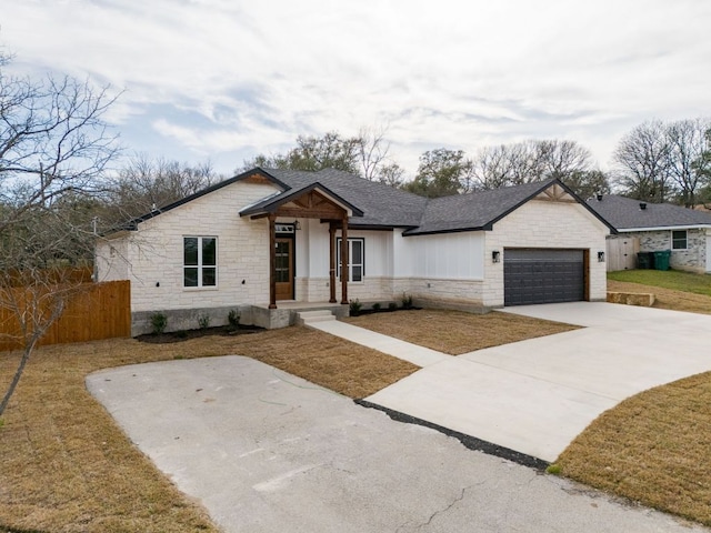 modern inspired farmhouse featuring fence, driveway, roof with shingles, a garage, and stone siding