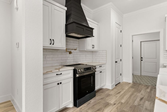 kitchen with custom exhaust hood, white cabinets, light wood-style floors, and electric range oven