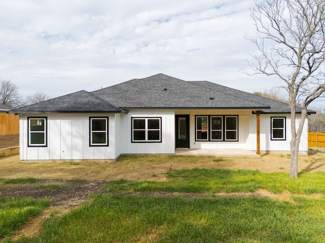 rear view of house with a patio, board and batten siding, a shingled roof, and fence