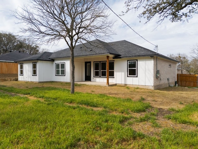 rear view of house featuring a patio, board and batten siding, a shingled roof, and fence