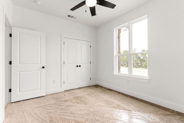 unfurnished bedroom featuring visible vents, ceiling fan, carpet, baseboards, and a closet