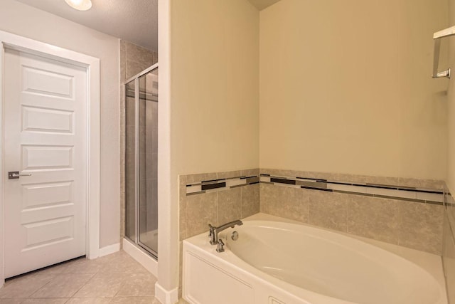 bathroom featuring tile patterned floors, a stall shower, and a bath