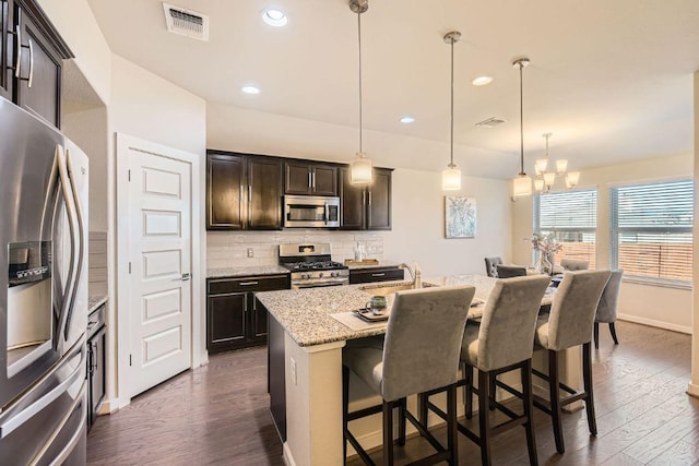 kitchen featuring dark wood-style floors, tasteful backsplash, a chandelier, and stainless steel appliances