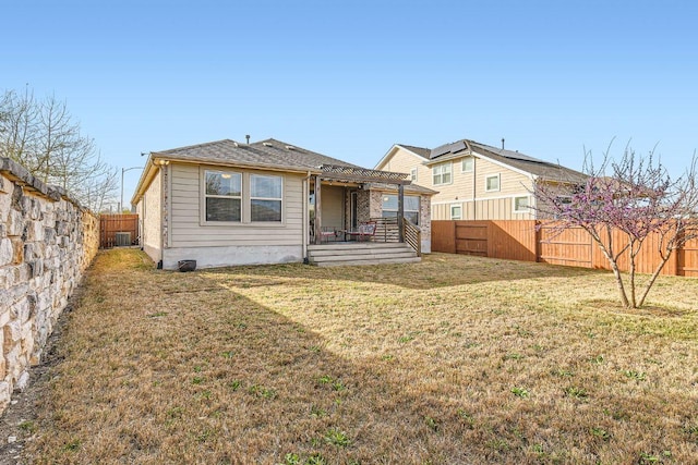 back of house featuring a lawn and a fenced backyard