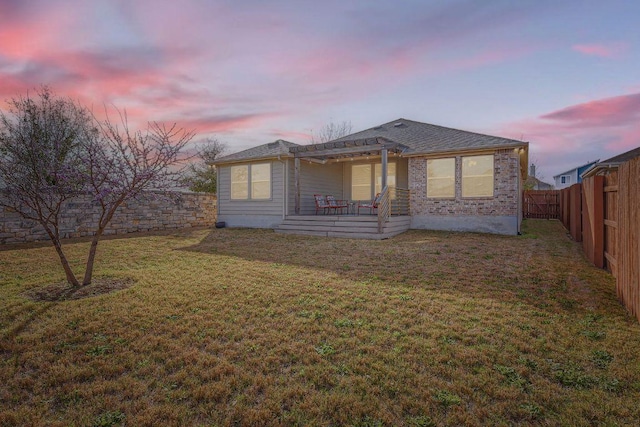 rear view of property featuring roof with shingles, a yard, a fenced backyard, a pergola, and a patio area