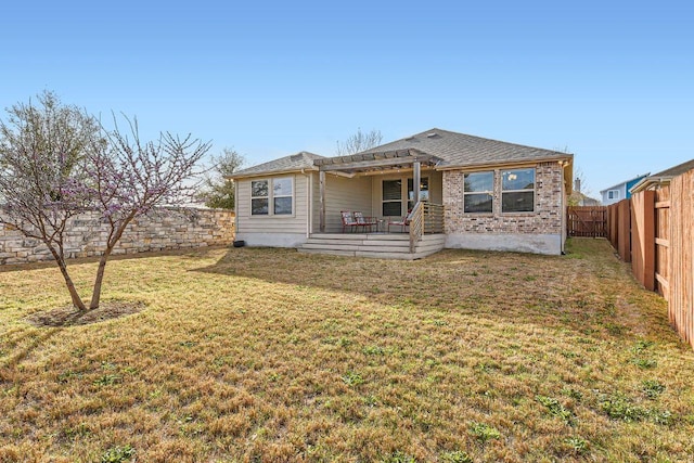 rear view of property featuring a shingled roof, a fenced backyard, a pergola, and a lawn