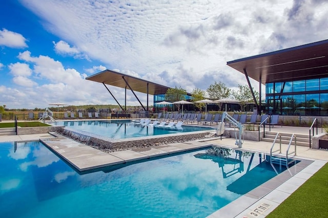 pool with a patio area and fence