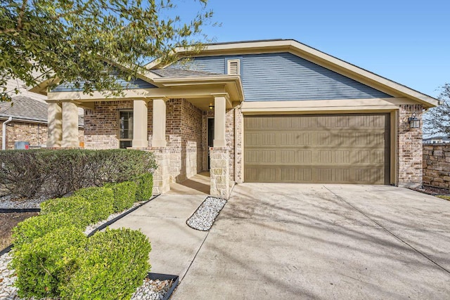 view of front of house featuring brick siding, an attached garage, and driveway