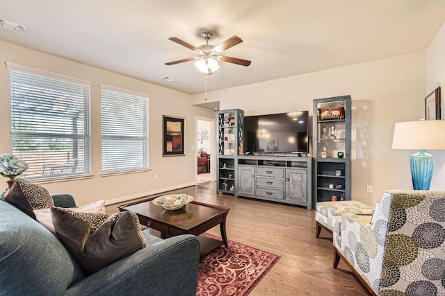 living area featuring visible vents, ceiling fan, and wood finished floors