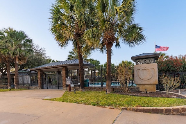 view of property's community featuring concrete driveway and fence