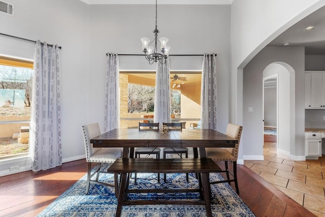 3206 Douglas Dr, Horseshoe Bay, TX 78657 - dining space with healthy amount of natural light, arched walkways, light wood-style flooring, a chandelier, and a towering ceiling