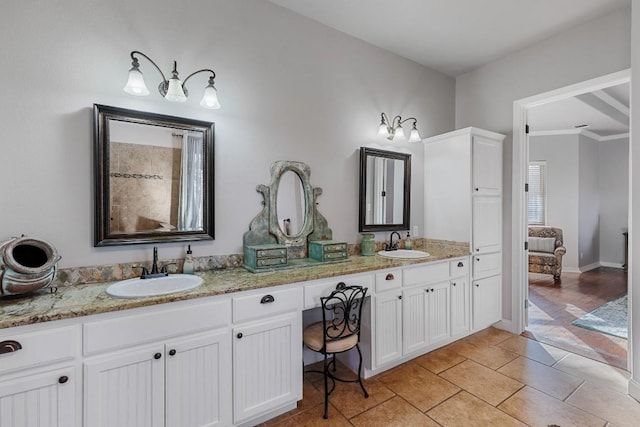 bathroom with tile patterned flooring, double vanity, baseboards, and a sink