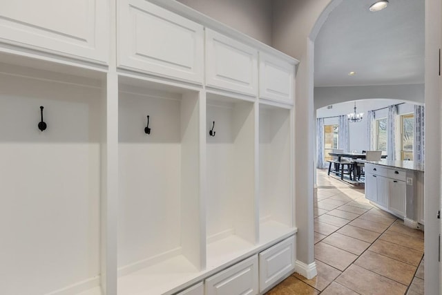 mudroom with a notable chandelier, recessed lighting, arched walkways, and light tile patterned floors