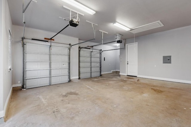 garage featuring electric panel, a garage door opener, and baseboards