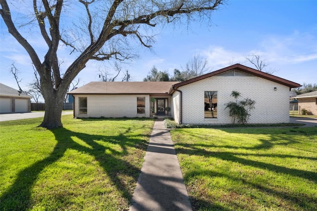 mid-century inspired home featuring brick siding and a front yard