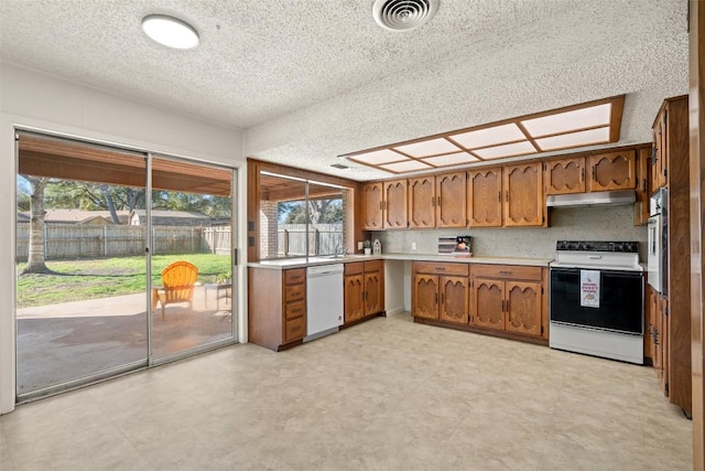 kitchen featuring visible vents, electric range oven, brown cabinetry, light countertops, and dishwasher