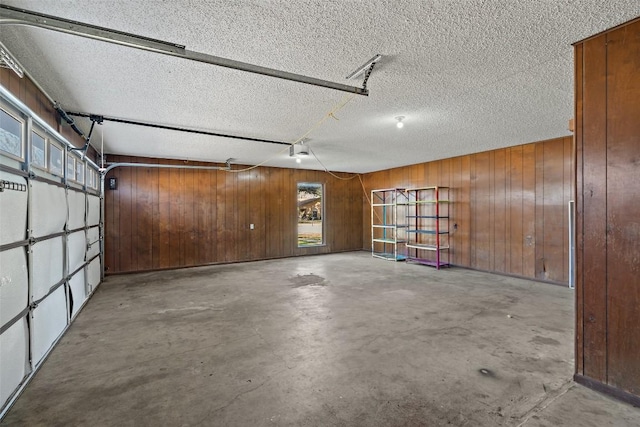 garage featuring wood walls and a garage door opener