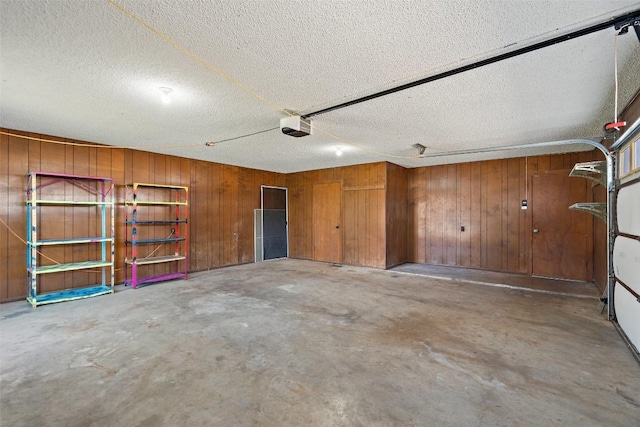 garage with wood walls and a garage door opener