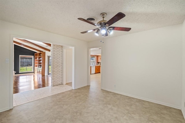 empty room with lofted ceiling with beams, baseboards, a textured ceiling, and a ceiling fan