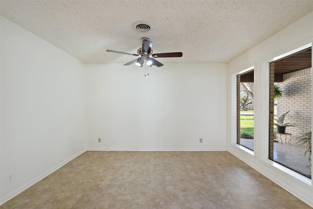 unfurnished room with baseboards, visible vents, a textured ceiling, and ceiling fan