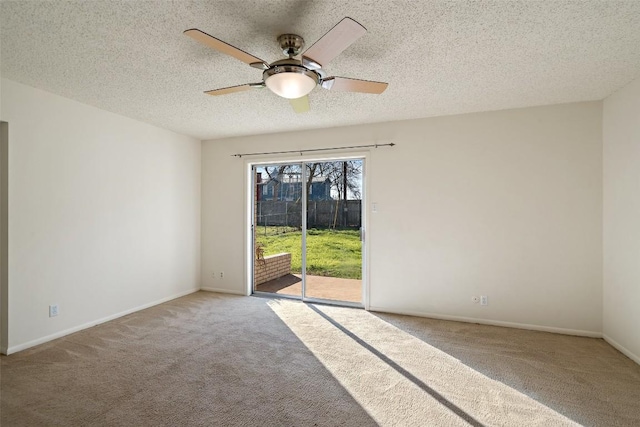 carpeted empty room featuring a textured ceiling, baseboards, and a ceiling fan