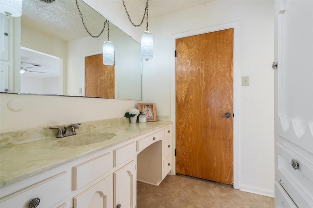 bathroom featuring vanity, ceiling fan, and a textured ceiling