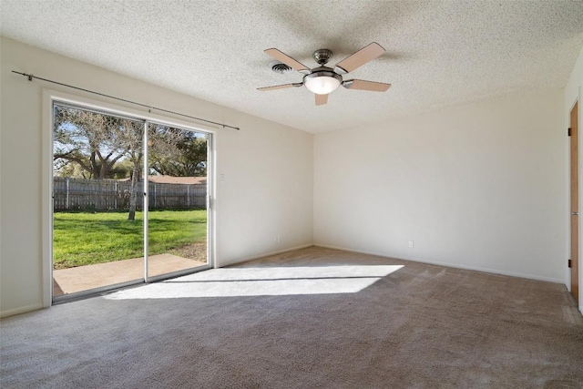 carpeted spare room with a textured ceiling and ceiling fan