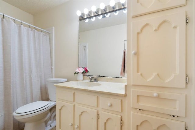 bathroom with a textured ceiling, toilet, and vanity