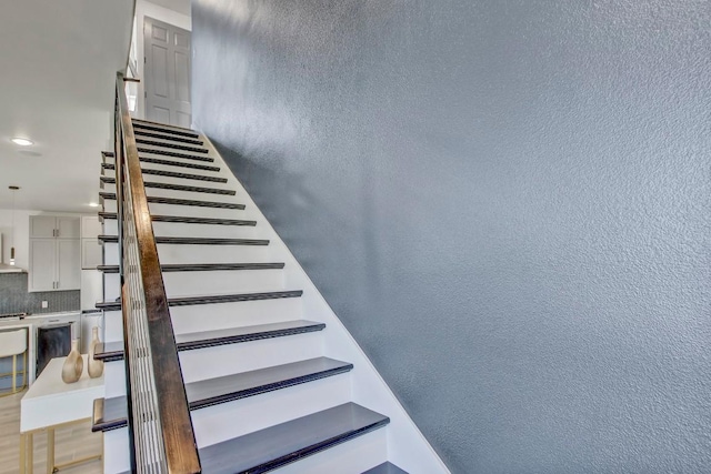 stairs featuring a textured wall