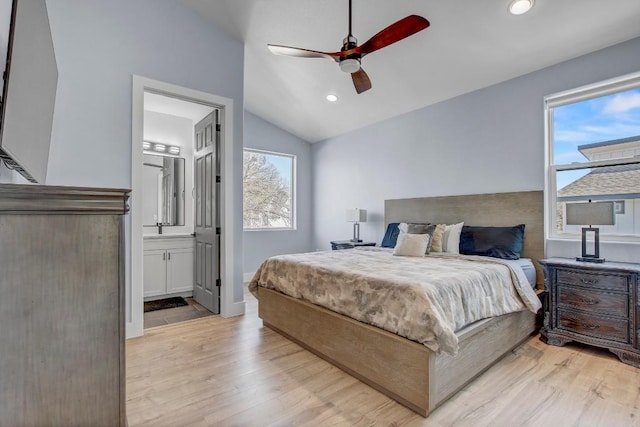 bedroom featuring recessed lighting, lofted ceiling, ensuite bathroom, and light wood finished floors