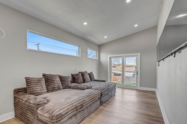 living area with recessed lighting, light wood-style flooring, lofted ceiling, and baseboards