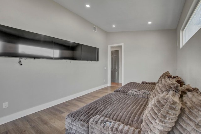 bedroom with visible vents, lofted ceiling, wood finished floors, recessed lighting, and baseboards