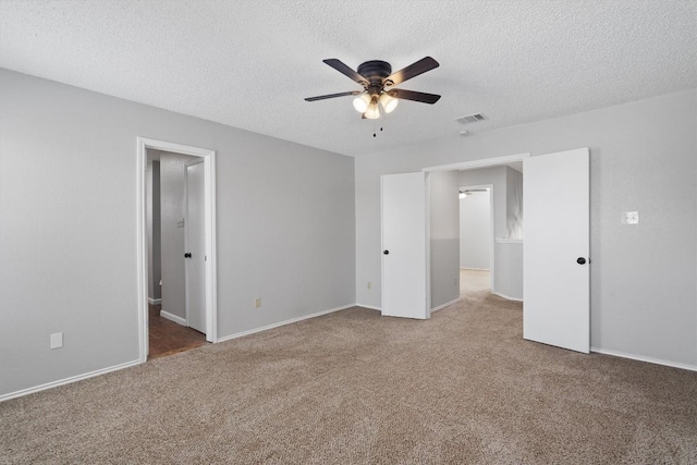 unfurnished bedroom featuring visible vents, baseboards, ceiling fan, carpet, and a textured ceiling