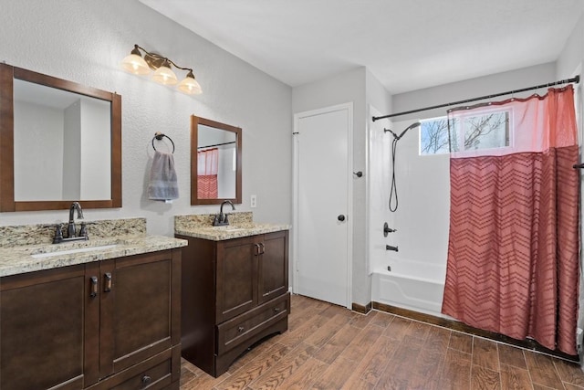 full bathroom featuring a sink, shower / tub combo with curtain, two vanities, and wood finished floors