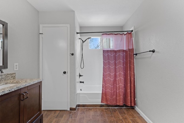 full bath with baseboards, shower / tub combo, vanity, and wood tiled floor